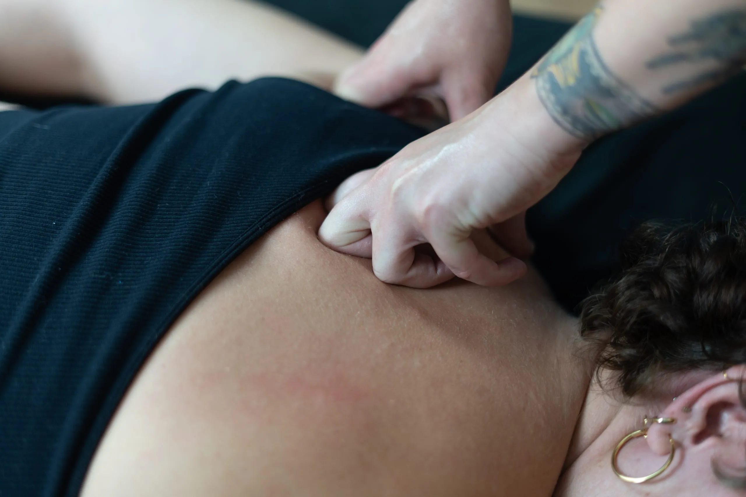 Isabelle's hands pressing into a knot in a client's back